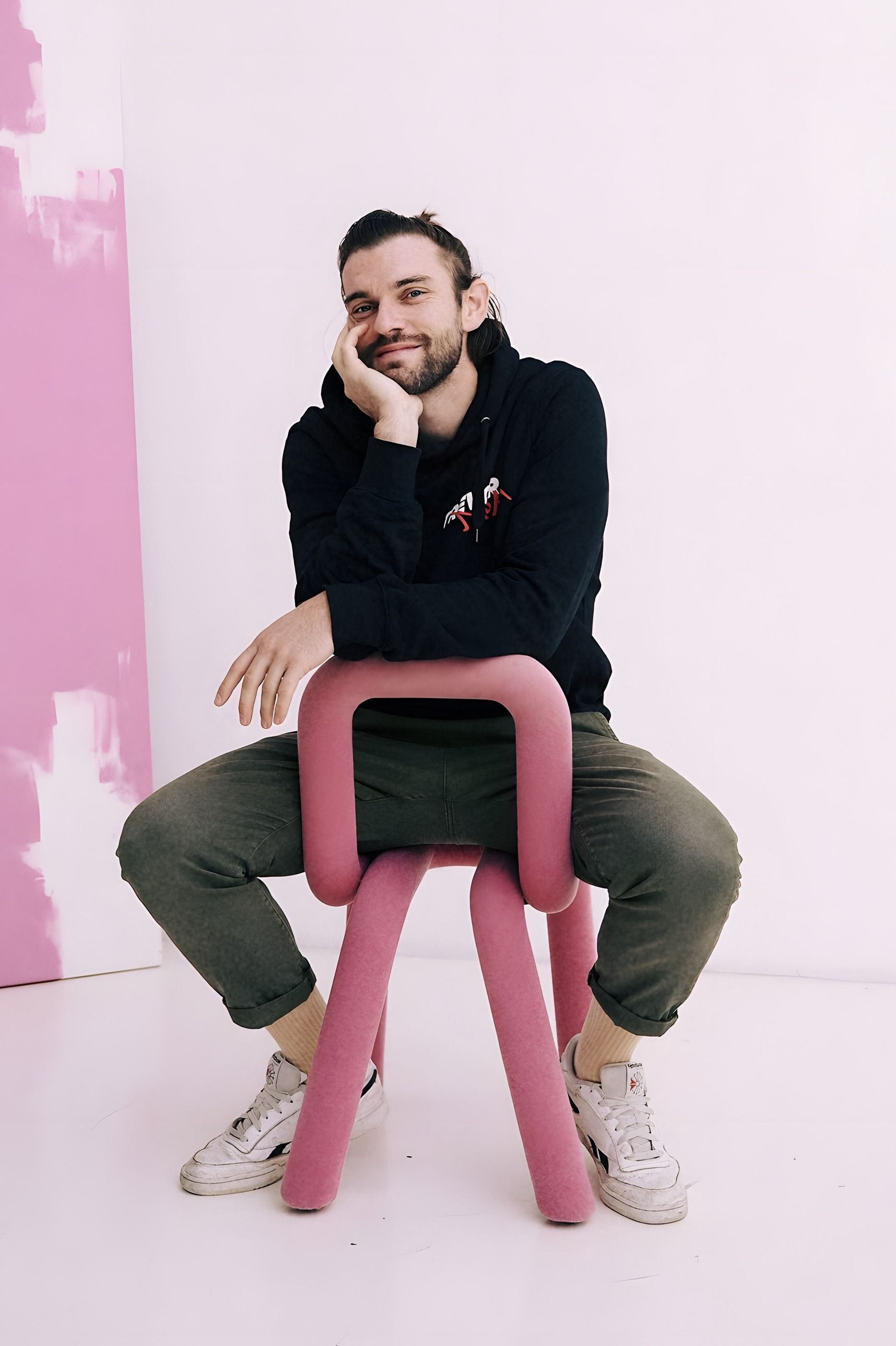 Kilian Amrehn, Fotograf in Köln, auf einem rosa Stuhl