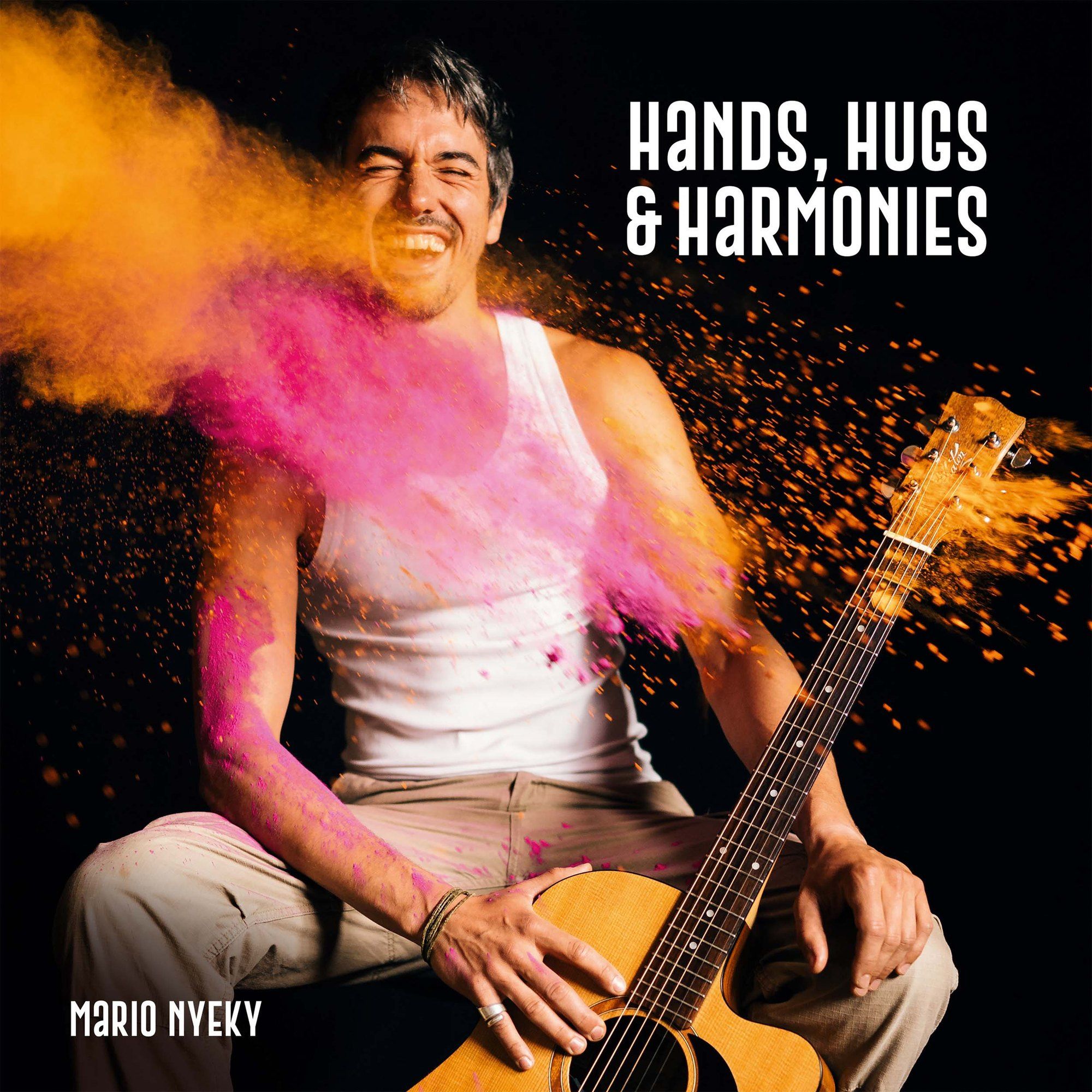 Mario Nyeky, album cover Hands, Hugs & Harmonies, laughing with a guitar in exploding pink and orange powder, 2021, photographed by Kilian Amrehn
