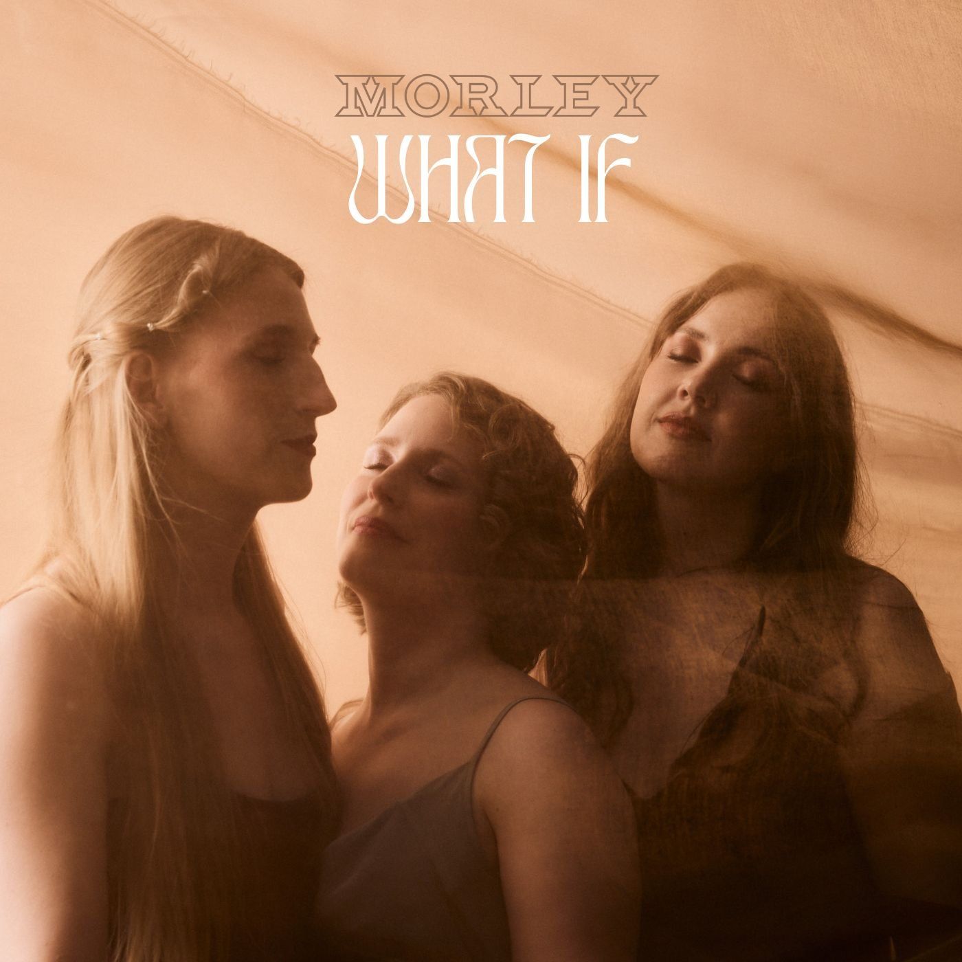 Morley, album cover What If, three women with eyes closed standing close together in warm peach light, 2025, photographed by Kilian Amrehn