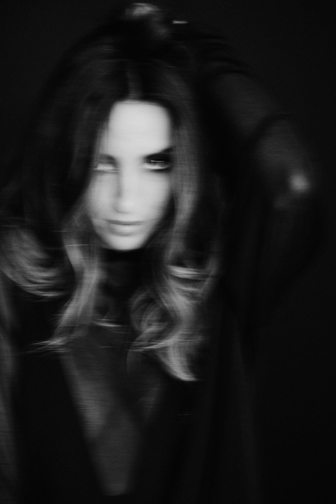 Nicole Da Silva, musician, blurred portrait with long hair and a gaze through her hair, black and white, 2025, photographed by Kilian Amrehn