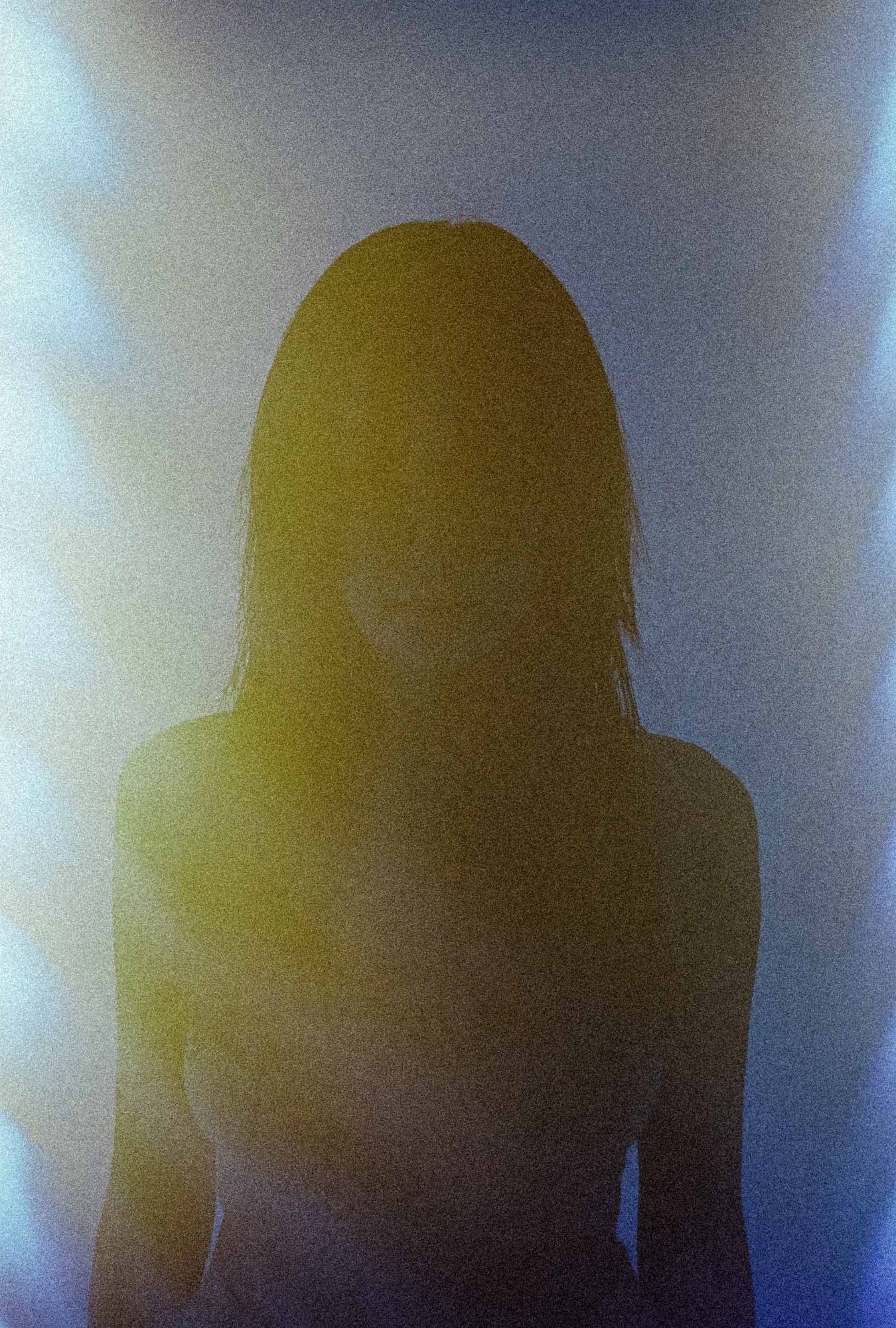Silhouette of a woman with long hair against the light, flares of blue and yellow, 2021, photographed by Kilian Amrehn