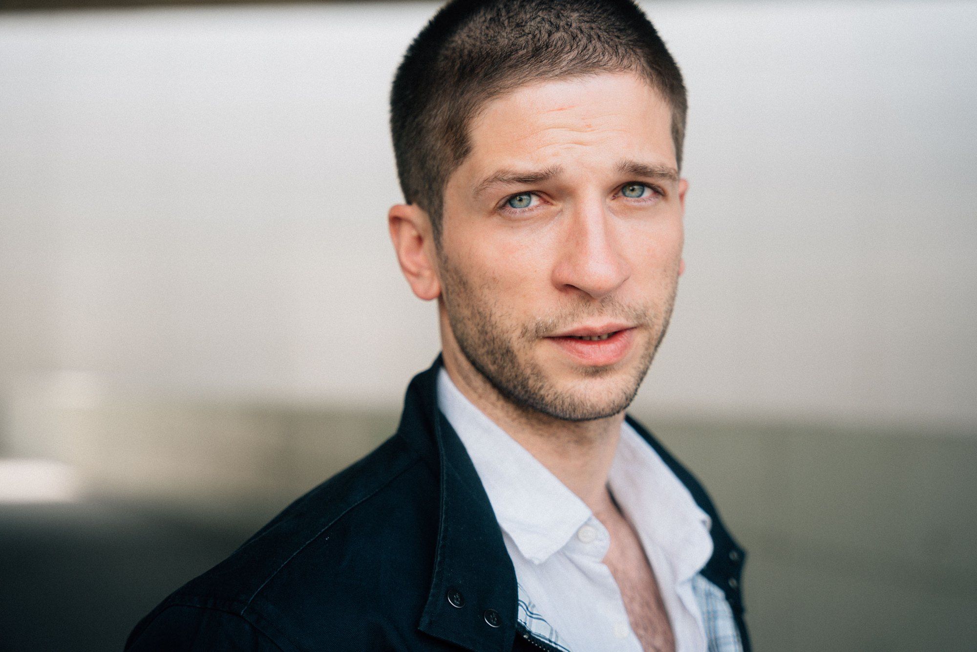 Slavko Popadić, headshot with short hair and stubble, dark jacket over a white shirt in daylight, 2022, photographed by Kilian Amrehn