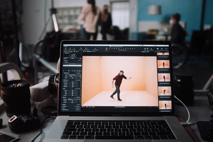 Laptop on set showing a shot of a dancer in the studio, crew in the background, flash by Kilian Amrehn