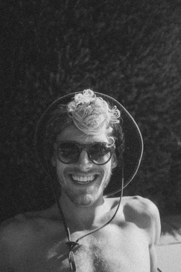 Laughing man in sunglasses under a transparent dome, black and white, flash by Kilian Amrehn