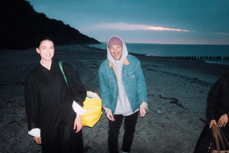 Two laughing friends on a beach at blue dusk, flash lit, flash by Kilian Amrehn