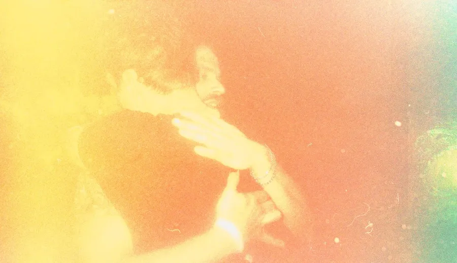 Analogue, heavily overexposed in orange and yellow: two people in a close embrace at Zugvögel festival, flash by Kilian Amrehn