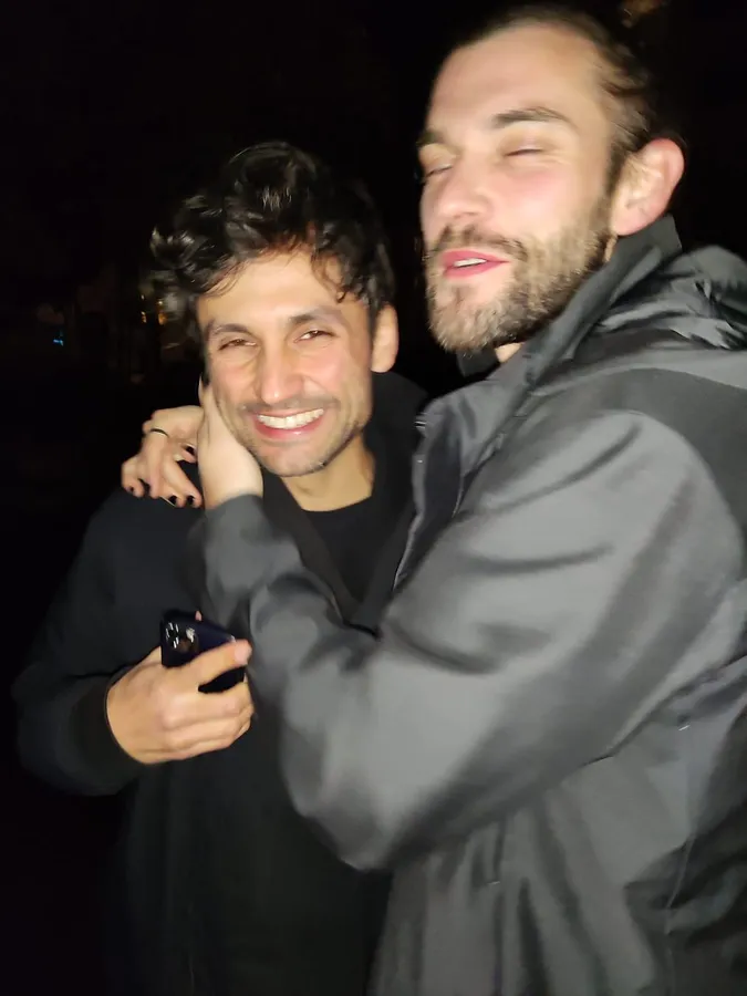 Two men hugging at night in flash light, both laughing with closed eyes, flash by Kilian Amrehn
