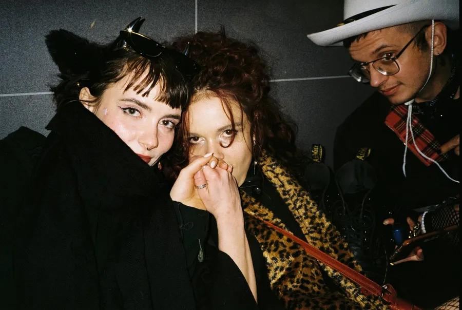 Three friends with cat ears, leopard coat and white hat in a dark stairwell, flash by Kilian Amrehn