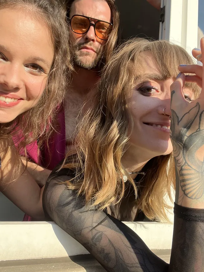Selfie of three friends from a window, tattooed arm and sunglasses, flash by Kilian Amrehn