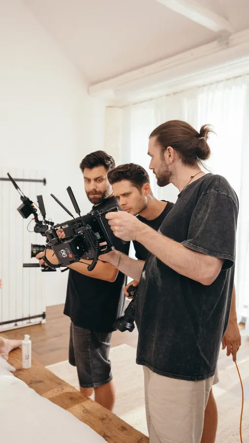 Film crew checking a camera on a gimbal in a bright room, flash by Kilian Amrehn
