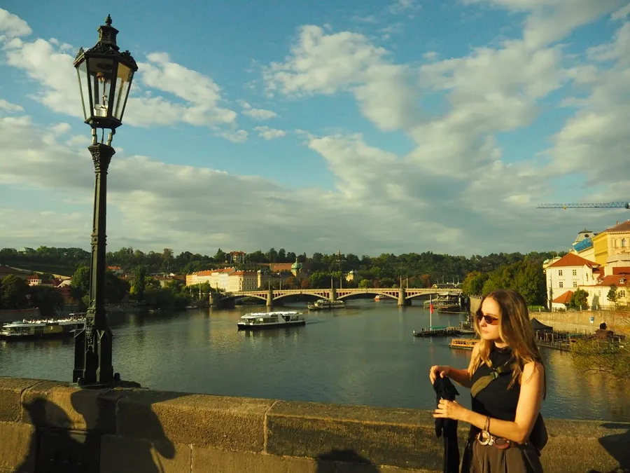 Woman in sunglasses on Charles Bridge, view over the Vltava, Prague, flash by Kilian Amrehn