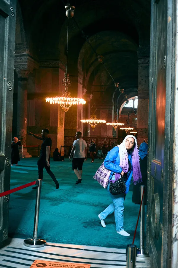 Woman in a headscarf with bags in the entrance of Hagia Sophia, Istanbul, flash by Kilian Amrehn