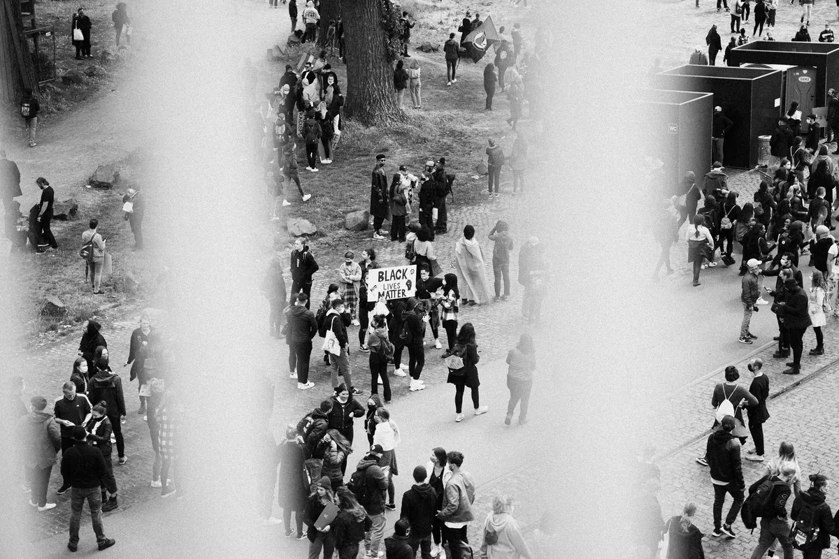 Menschenmenge mit Black-Lives-Matter-Schild auf dem Rheinufer, Aufsicht, schwarzweiß, Black Lives Matter Köln 2020, Reportage von Kilian Amrehn