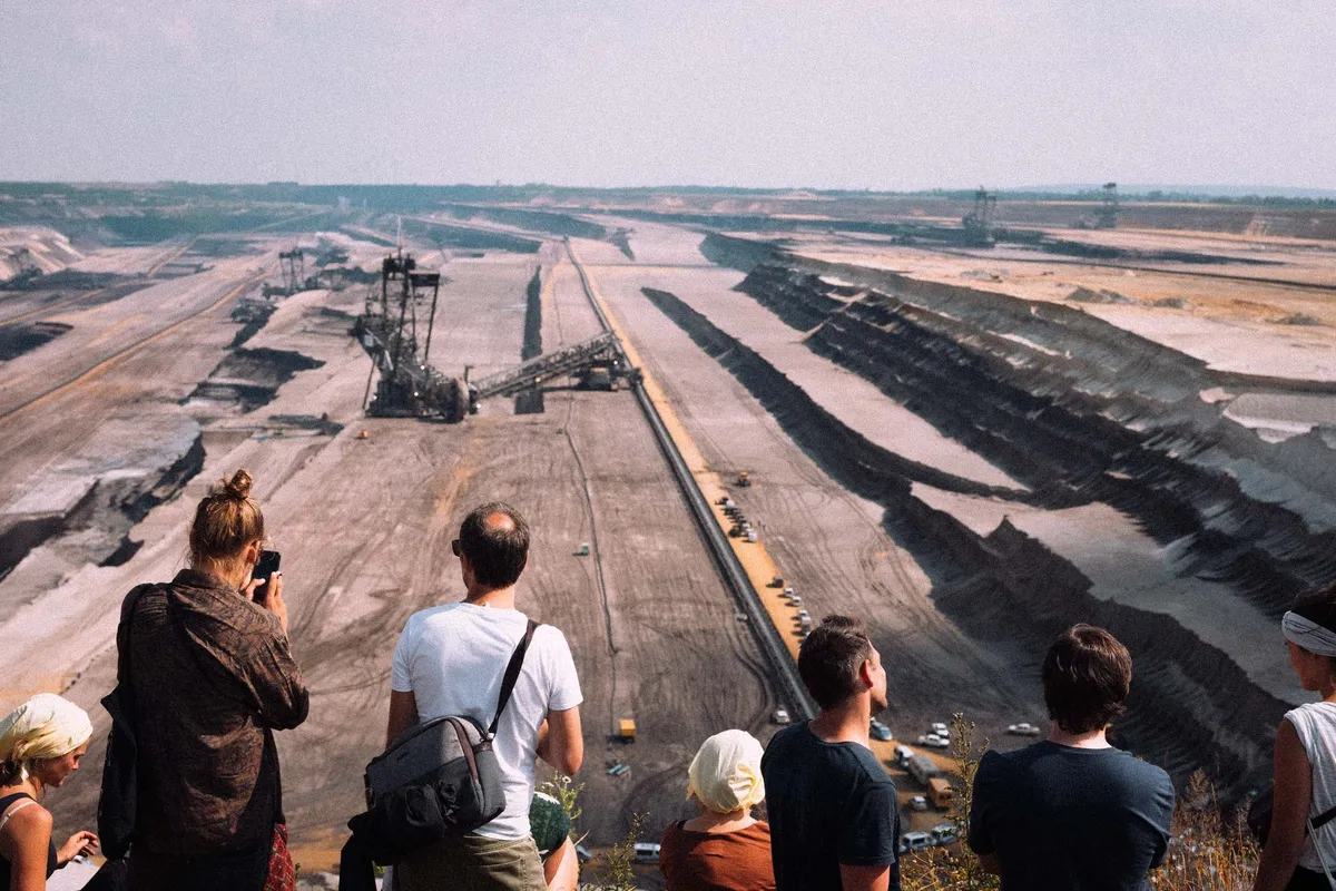 Menschen am Rand blicken in den Tagebau mit Schaufelradbagger und Abbauterrassen, Fridays for Future Garzweiler 2019, Reportage von Kilian Amrehn