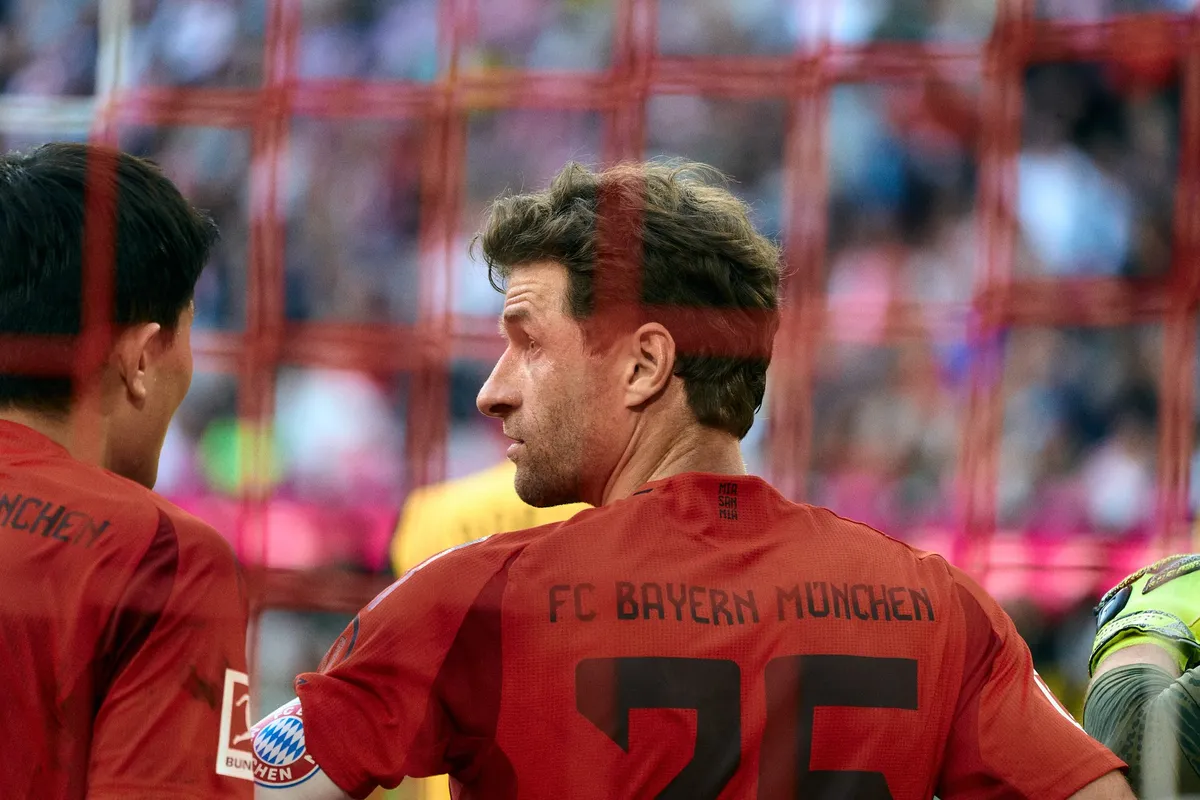 Bundesliga, Spieler im roten FC-Bayern-München-Trikot mit Nummer 25 durch das Tornetz fotografiert, Sportfotografie, fotografiert von Kilian Amrehn
