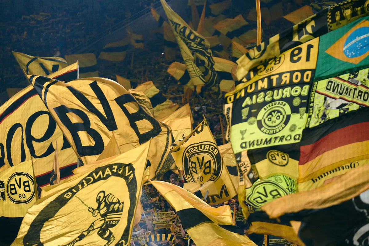 Bundesliga, sea of yellow and black BVB flags in the fan stand with Borussia Dortmund crests, sports photography, photographed by Kilian Amrehn