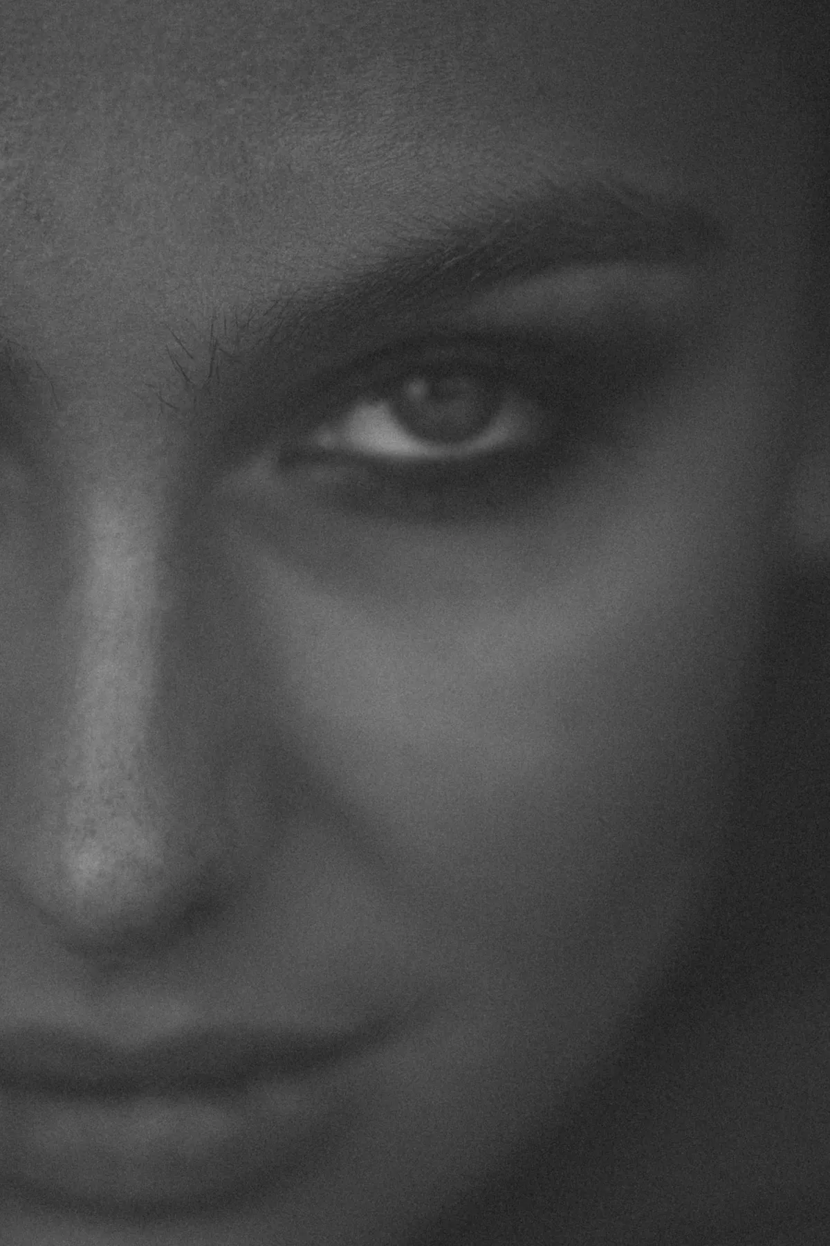 Marie, close-up glancing over her shoulder with a slight smile, face half in shadow, black and white, 2022, photographed by Kilian Amrehn