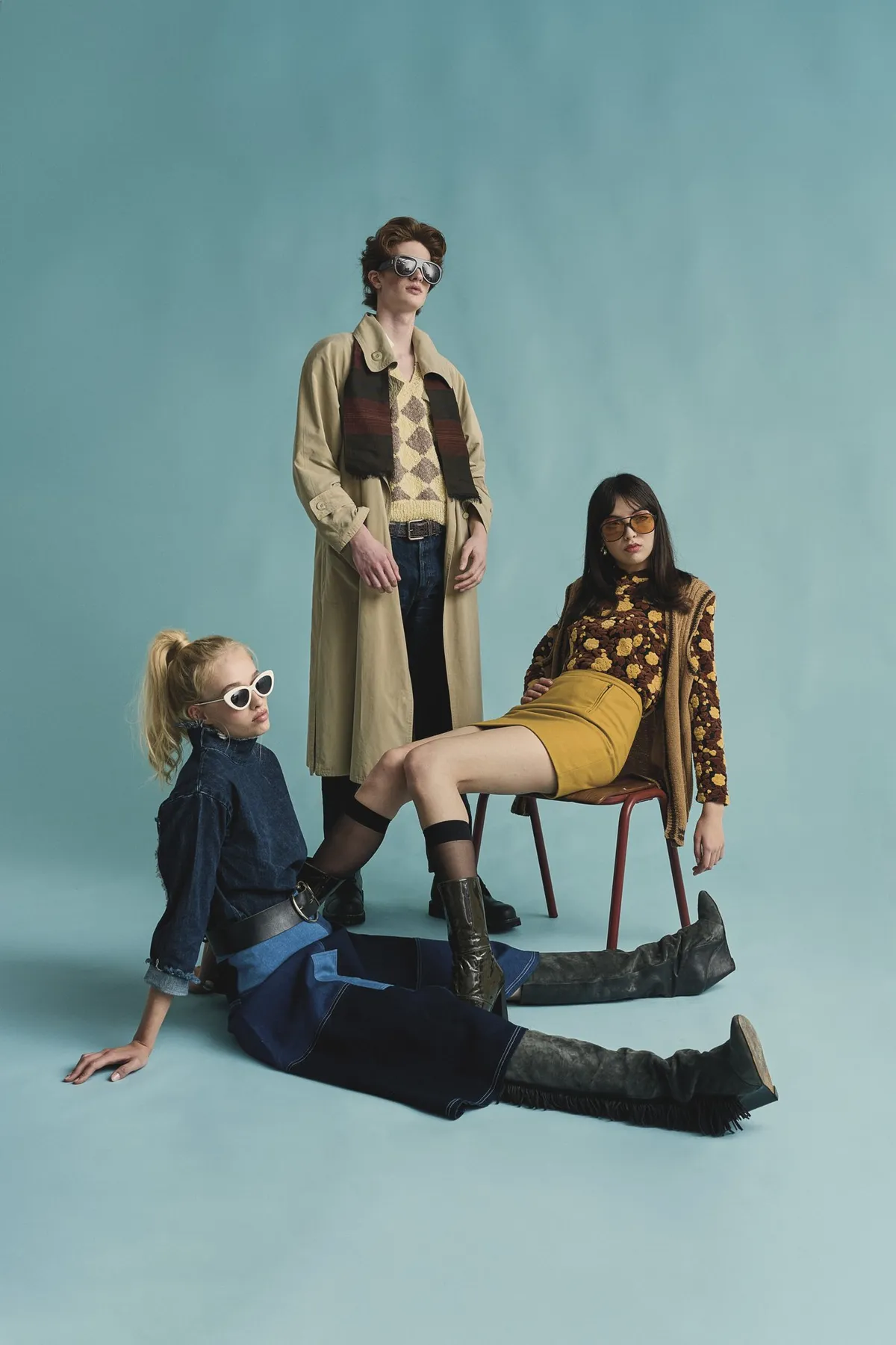 New Icons' Club Magazine, three models in second-hand looks with trench coat, denim and boots against pale blue, editorial 2nd Hand 2024, photographed by Kilian Amrehn