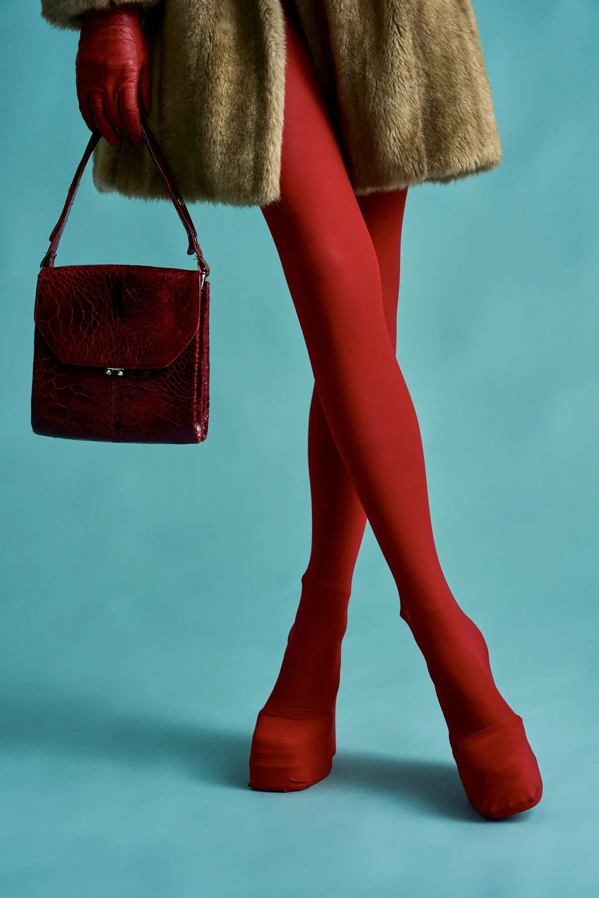 New Icons' Club Magazine, legs in red tights, a red croc handbag and fur coat against a teal background, editorial 2nd Hand 2024, photographed by Kilian Amrehn