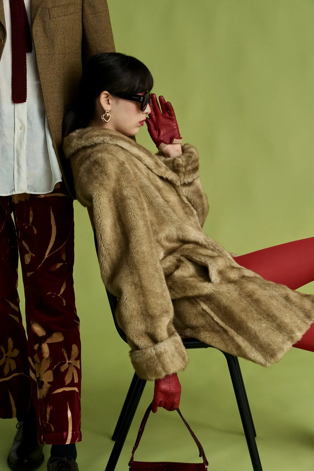 New Icons' Club Magazine, model in a fur coat reclining on a chair beside legs in patterned velvet trousers, olive green backdrop, editorial 2nd Hand 2024, photographed by Kilian Amrehn