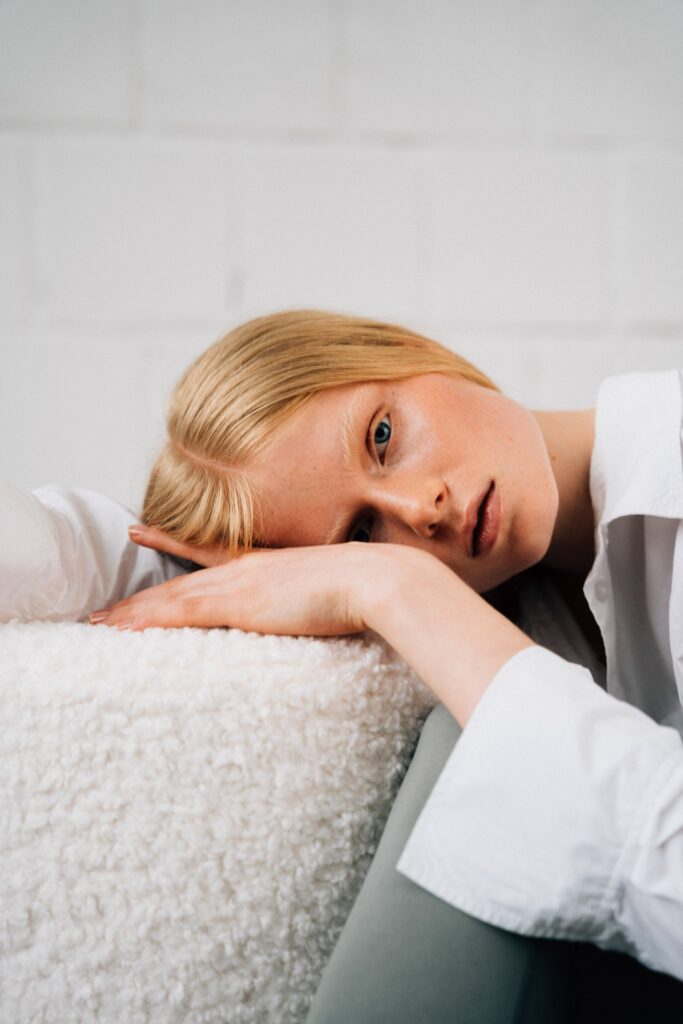 Foto von einem Model auf einem Plüsch-Sofa in weiß