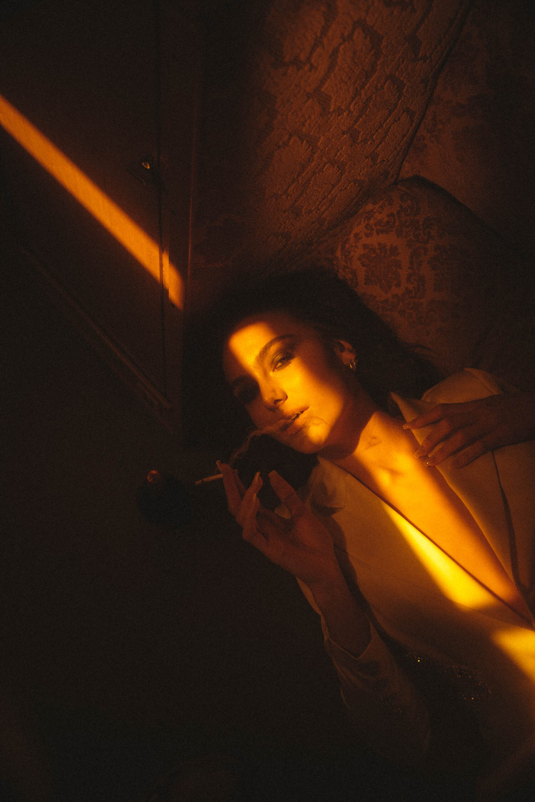 Foto von einem rauchenden Model in einem dunklen Raum