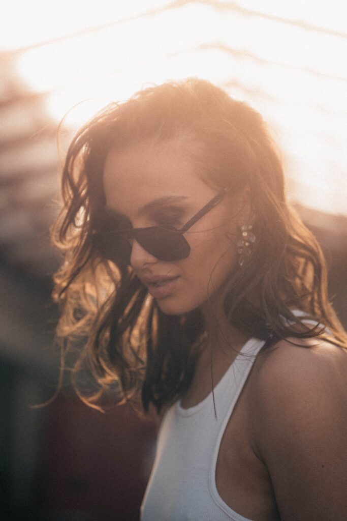 Foto von einem Model mit einer Sonnenbrille und Ohrschmuck