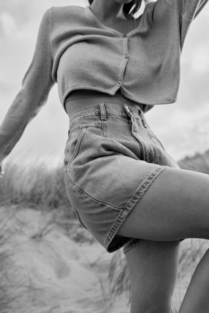 Schwarz-Weiß Fotoshooting von einem Model in kurzer Jeans am Strand mit PNTS