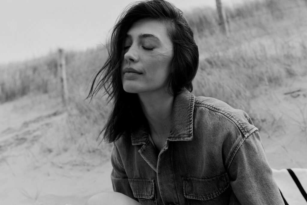 Schwarz-Weiß Fotoshooting von einem Model in Jeansjacke am Strand