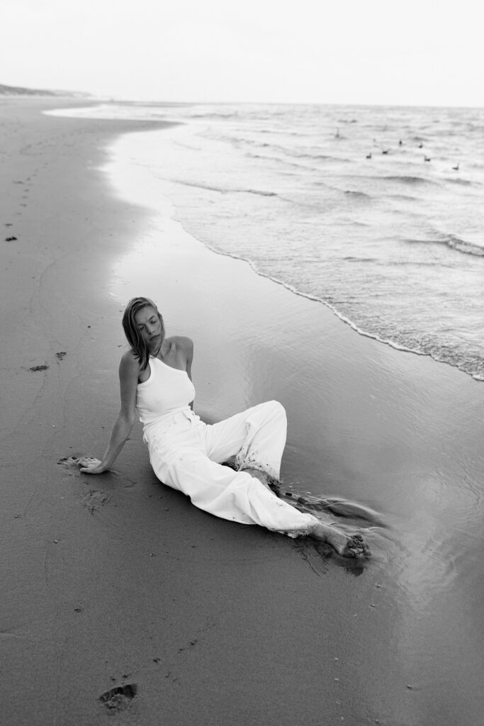 Schwarz-Weiß Fotoshooting von einer Frau am Strand mit heller Kleidung